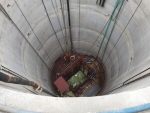 A pre-sink stage in a concrete-lined shaft with services erected, illustrating the structured approach that safeguards workers as infrastructure is progressively installed.